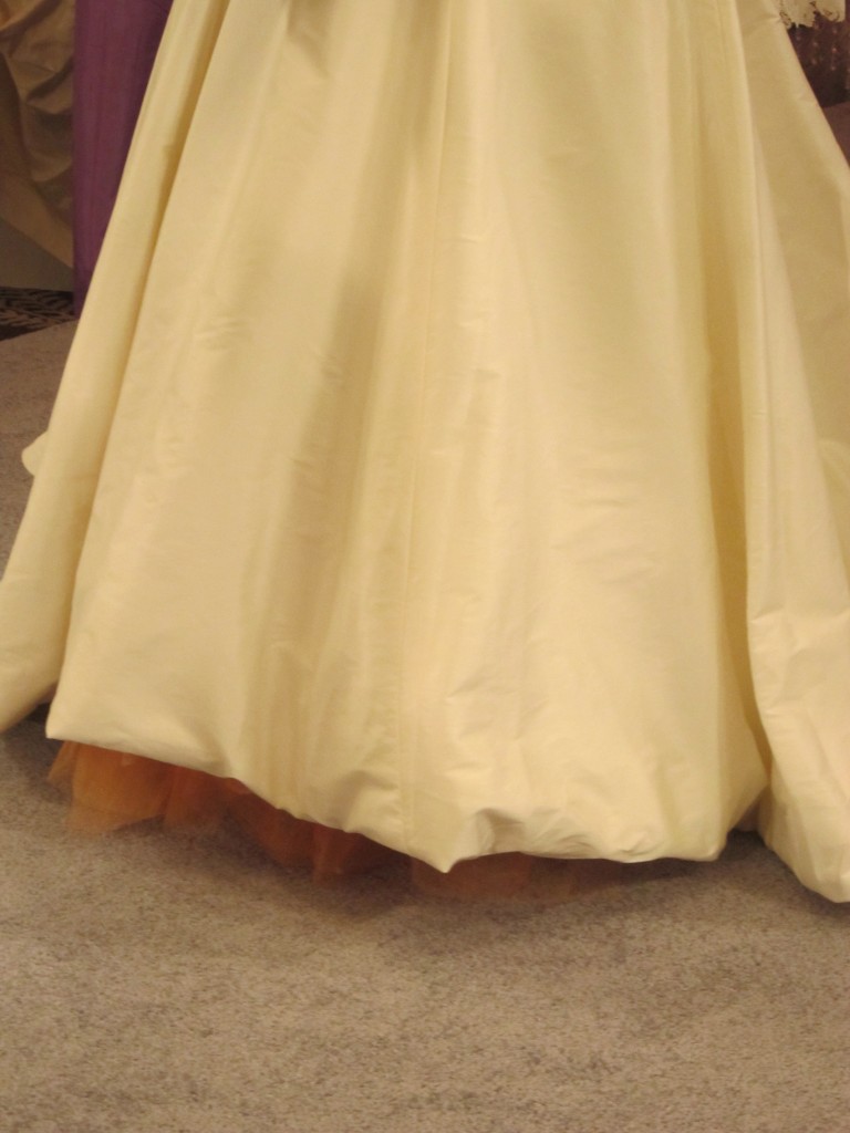 An unexpected hint of orange tulle peaking out from under the skirt tied in with her wedding colors.